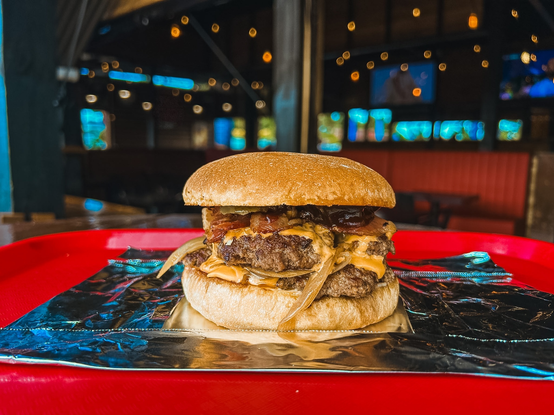 Double cheese and bacon burger on a red tray