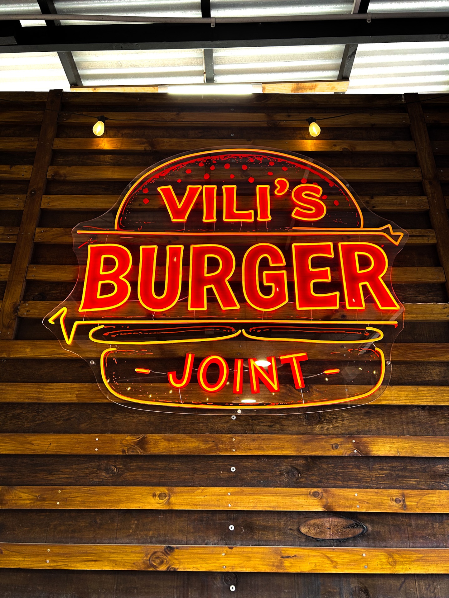 Vili's Burger Joint neon storefront sign on rustic wood
